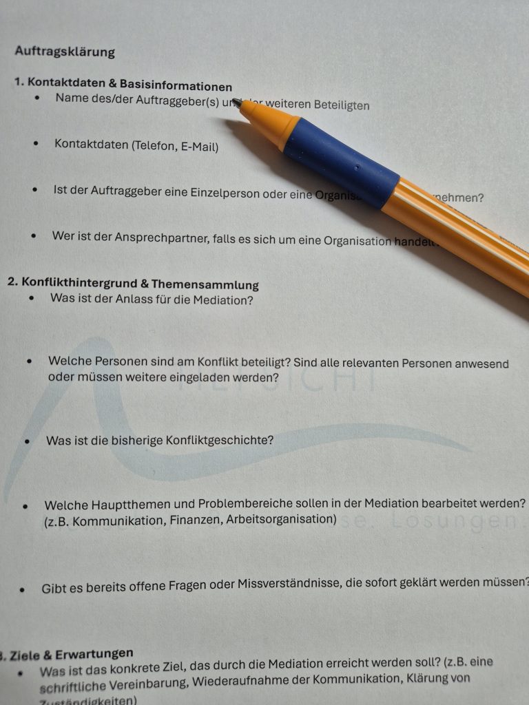 Ein Zettel zur Auftragsklärung mit einem Stift